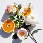 Naranja, rosa y flor de tiaré representando las notas olfativas del perfume.