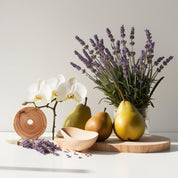 Pera, lavanda, orquídea y madera representando las notas olfativas del perfume.